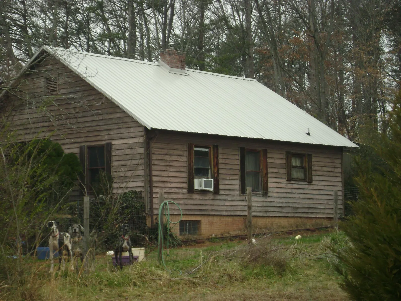 White metal roof on an old wood sided farmhouse, from a Metal Roof Installation job in Amherst